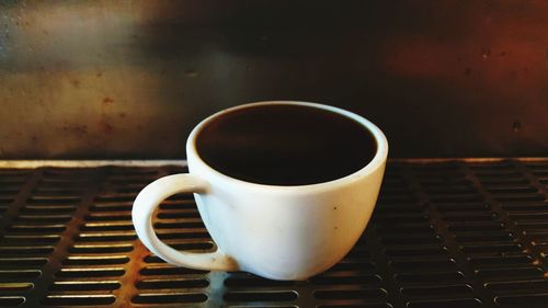 Close-up of black coffee on metal grate