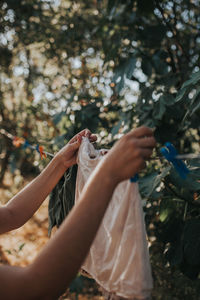 Cropped hand of woman drying clothes on clothesline