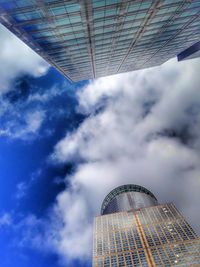 Low angle view of modern building against cloudy sky