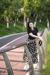 Portrait of woman standing against trees