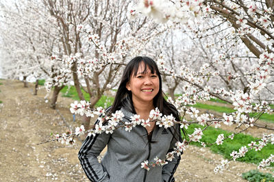 Portrait of smiling young woman with cherry blossom