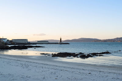 View of the museum of the sea lighthouse from carril beach in vigo - spain