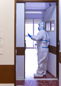 Rear view of man working at entrance of building