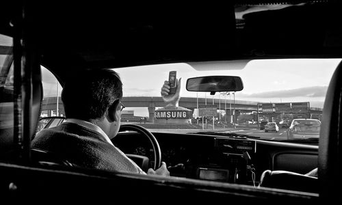 Rear view of man driving taxi in city