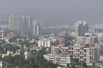 Aerial view of buildings in city against sky