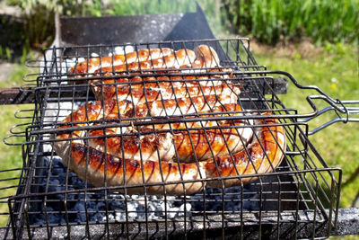 Grilling sausages on barbecue grill outside. cooking in nature in summer.