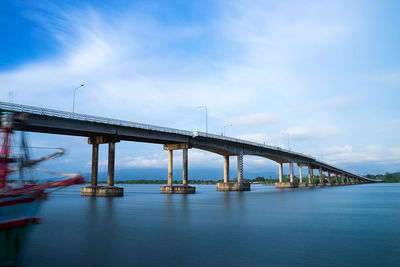 View of bridge over sea against cloudy sky