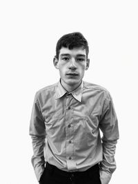 Portrait of young man standing against white background