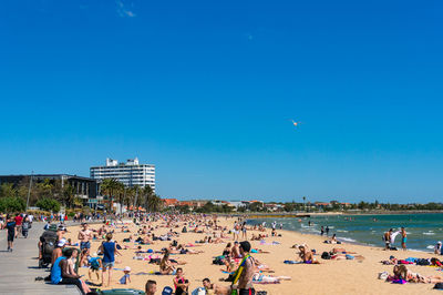 People on beach against blue sky