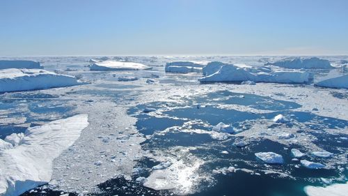 Aerial view of snow covered landscape against sky