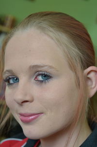 Close-up portrait of young woman smiling at home