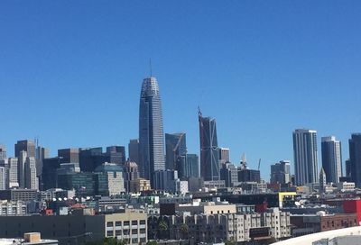 Skyscrapers in city against blue sky