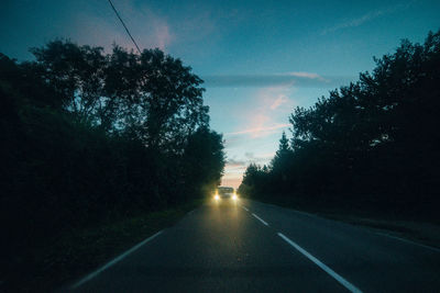 Empty road along trees