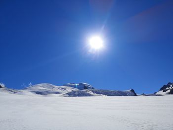 Scenic view of snowcapped mountains against clear blue sky