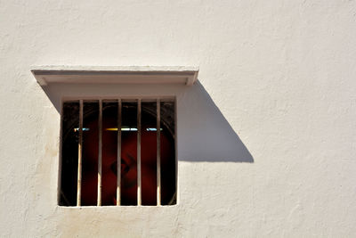 Low angle view of window on white wall