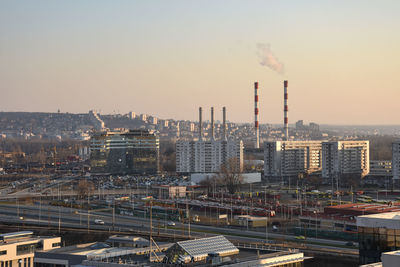 Smoke emitting from factory against sky