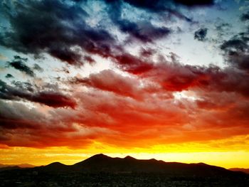 Silhouette of landscape against cloudy sky during sunset