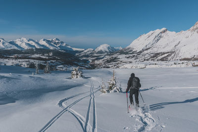 An unrecognizable male hiker wearing snowshoes running in the french alps on a cold winter day