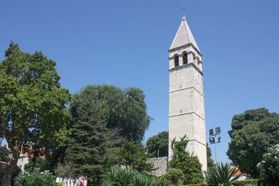 Low angle view of trees and building against sky