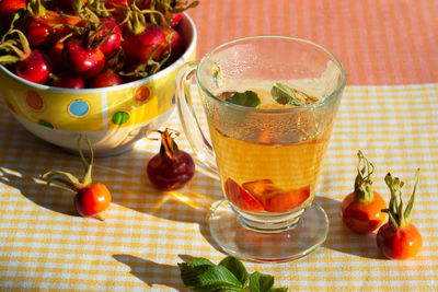 Rose hip tea and wild rose fruits in a bowl. close-up.