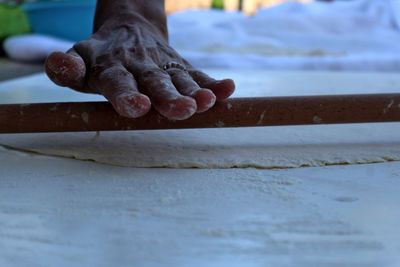 Close-up of woman working on table making turkish traditional food like rolling pizza dough