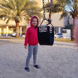 Portrait of smiling boy standing against tree