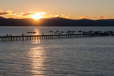 Pier over sea against sky during sunset