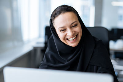 Portrait of young woman using laptop at home