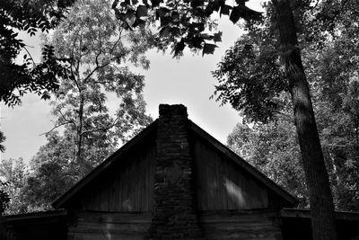 Low angle view of trees and building against sky