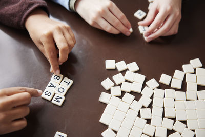 Children playing scrabble at dining table