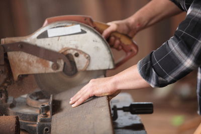 Midsection of carpenter working at workshop