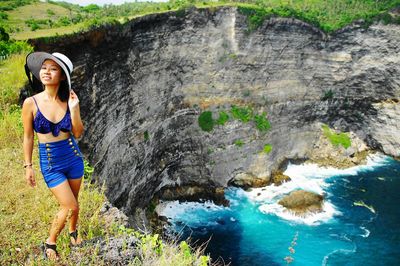 Portrait of smiling mid adult woman standing on cliff