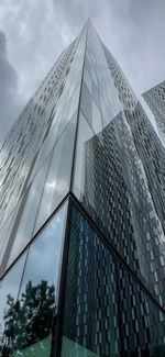 Low angle view of modern glass building against sky