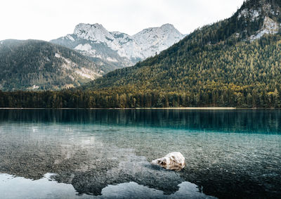 Scenic view of frozen lake in front of snow covered mountains