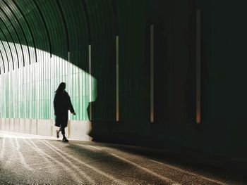 Rear view of man walking on corridor