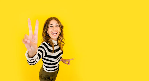 Portrait of a smiling young man against yellow background