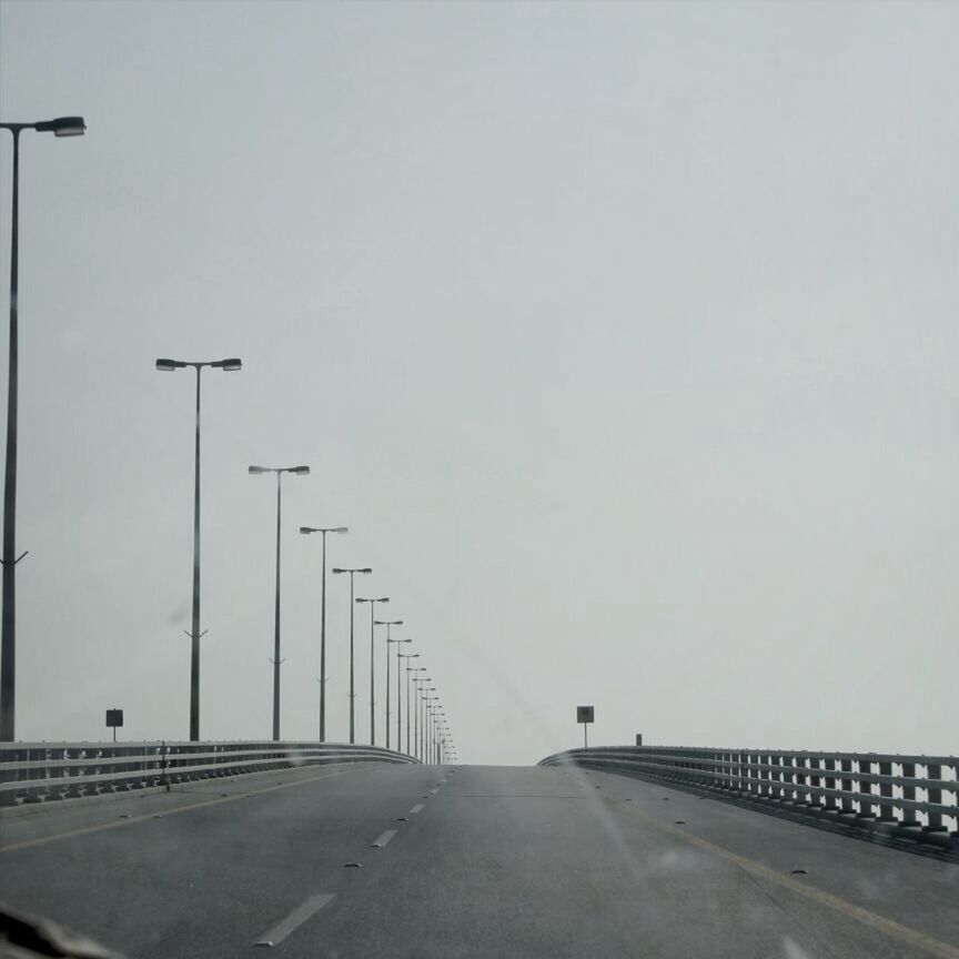 the way forward, transportation, road, road marking, clear sky, street light, copy space, diminishing perspective, street, vanishing point, empty, railing, built structure, empty road, car, asphalt, connection, outdoors, sky, long