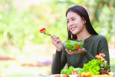 Young woman holding food outdoors