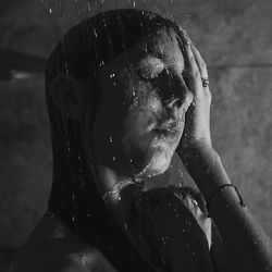 Close-up of woman bathing under shower in bathroom