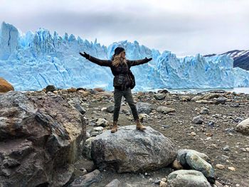 Full length of woman standing at beach during winter