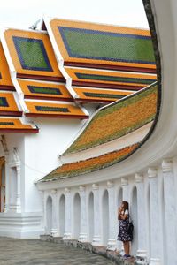 Woman praying while standing in temple