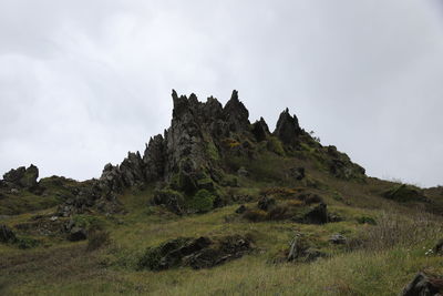 Scenic view of rocky crag on land against sky