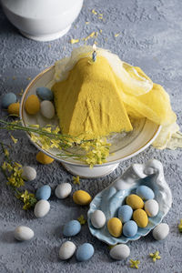 Traditional easter orthodox curd cake with yellow flowers on a grey table