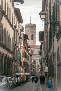 People on street amidst buildings in city