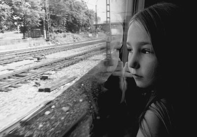 Portrait of young woman looking through train window
