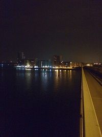 Illuminated cityscape against sky at night