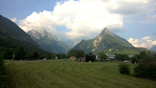Scenic view of green landscape and mountains against sky