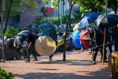 Rear view of people walking on street in city