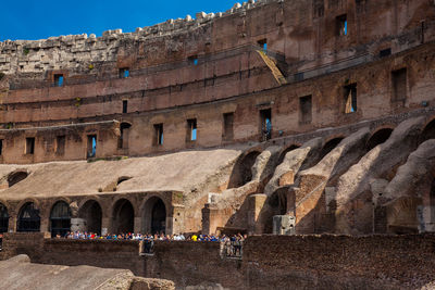 Tourists visiting the interior of the famous colosseum in rome