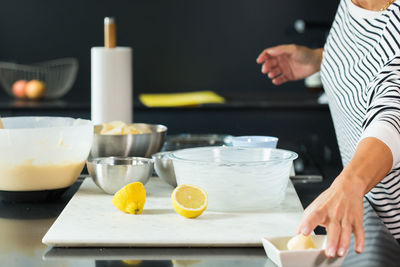 Woman kneading the dough while cooking apple pie in the modern kitchen